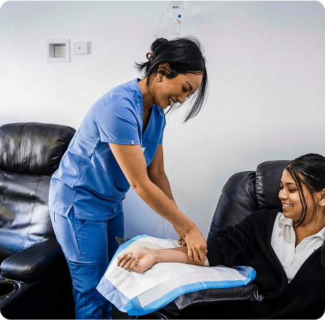 Smiling staff and happy client enjoying a positive experience during IV treatment at Fresh Treatment.