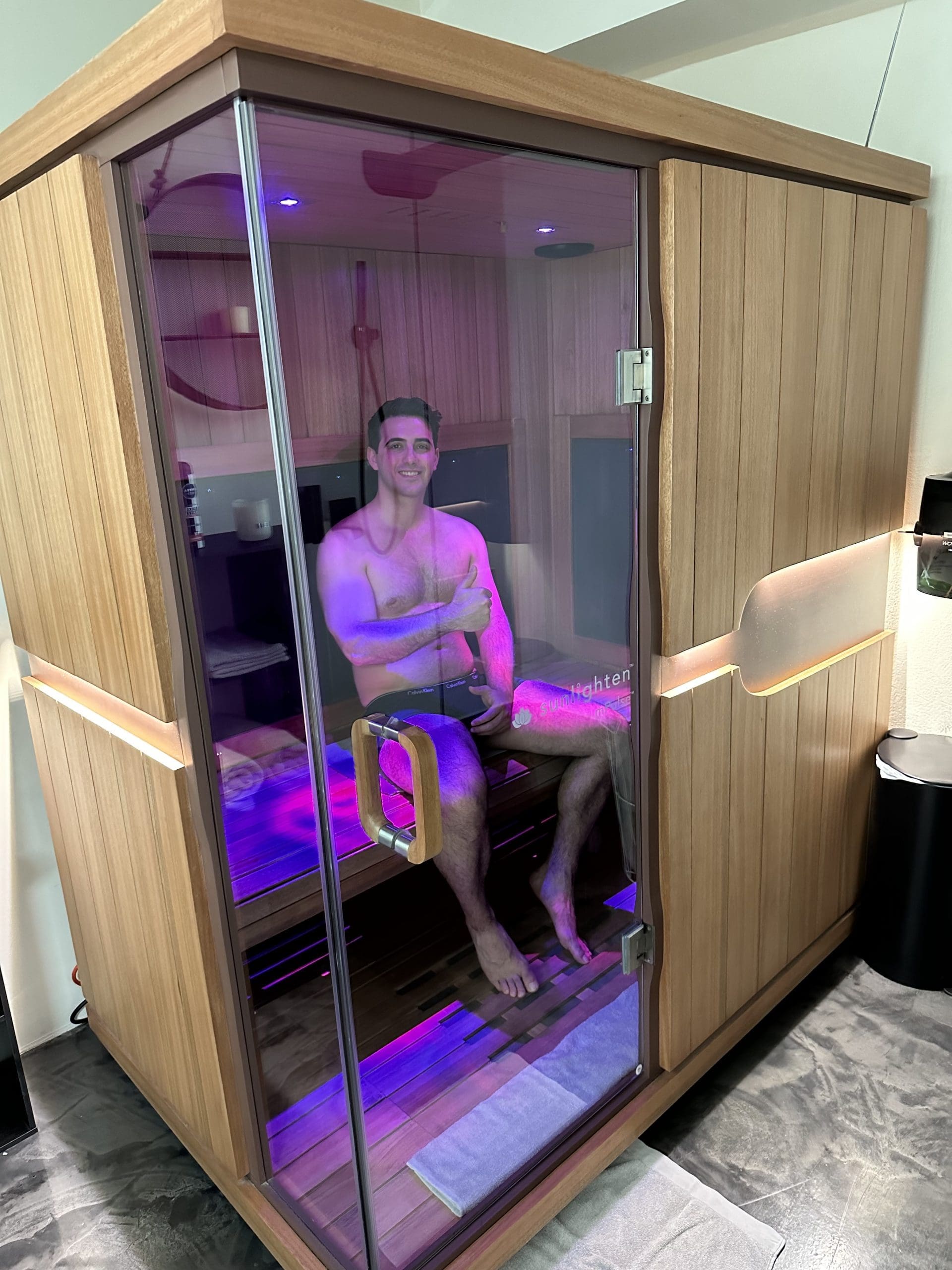 Person relaxing in a wellness clinic, receiving a treatment with soothing lighting and modern design elements in the background.