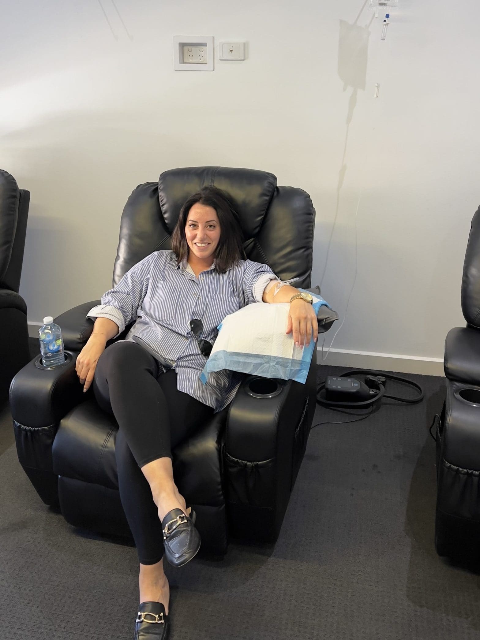 Relaxed woman sitting in a chair, receiving an IV infusion for wellness at Fresh Treatment.