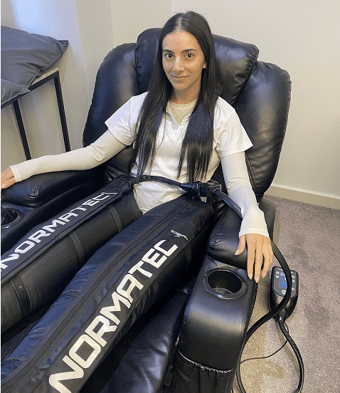 Isabelle, a receptionist at Fresh Treatment, enjoying a recovery session while wearing the Normatec pants.
