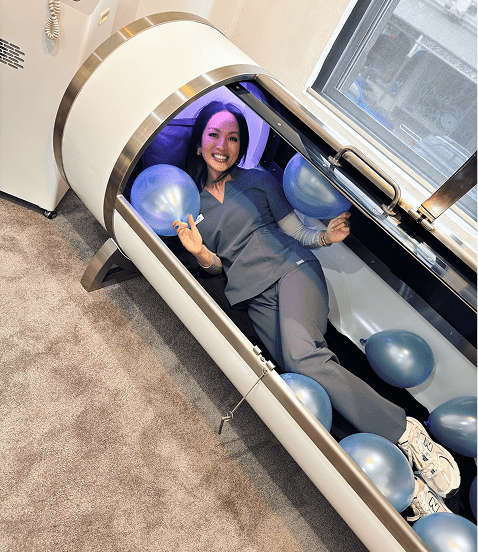 Tish, Fresh Treatment’s registered nurse, smiling and enjoying a session inside a wellness machine.